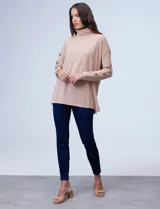 Polera negra de tejido soft con cuello alto y mangas largas con aplique de botones.