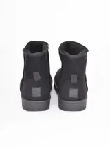 Bota de caña media color negro, con interior forrado en piel sintética y suela de goma antideslizante.