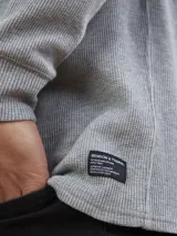 Remera de manga larga gris, confeccionada en tejido waffle.