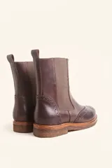 Bota tipo Chelsea de cuero vacuno color suela, con diseño brogue en la puntera y laterales. Presenta paneles elásticos laterales en color marrón oscuro, tirador trasero y suela de goma con plataforma.