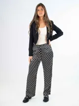 Pantalón de satén con estampado geométrico en blanco y negro, corte palazzo y cintura elástica con cordón ajustable.