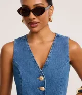 Chaleco de jeans con cuello en V, abotonado al frente con botones dorados y corte crop.