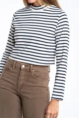 Polera de manga larga, corte ajustado al cuerpo, con cuello alto. Presenta un estampado de rayas horizontales en tonos marrón camel y azul marino.