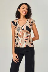 Blusa de poliéster sin mangas, con cuello en V y estampado abstracto multicolor en tonos beige, marrón, negro y naranja.