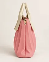 Bolso amplio en tono rosa con textura granulada y diseño de pliegues verticales, con asas en contraste color crema y herrajes dorados.