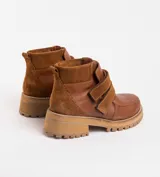 Bota corta de cuero vacuno color negro, con suela de caucho tipo tractor y cierre mediante doble tira de velcro en el empeine.