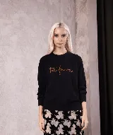 Sweater de punto color rosado con cuello redondo, mangas largas y el logo 'the farra' bordado en el frente.