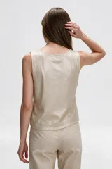 Chaleco sin mangas de viscosa color beige con escote en V y cierre frontal de botones.