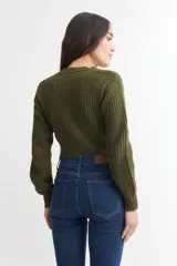 Cardigan de punto grueso en color bordó, con escote en V, cierre frontal de botones y mangas tipo balloon con puños ajustados.