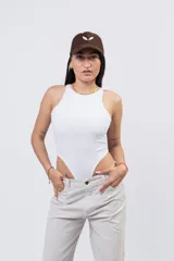 Body de algodón suave y elastizado de color blanco, con cuello a la base tipo halter y diseño cavado de tiro alto.