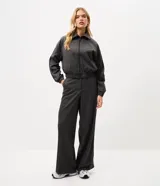 Pantalón de sastrería de corte recto y tiro medio, con estampa a cuadros en tonos de gris. Cuenta con cierre frontal discreto y detalles laterales contrastantes.