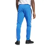 Pantalón de jogging azul con cintura elástica y cordón ajustable, bolsillos laterales con cierre y logo de Adidas bordado en blanco.