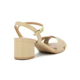 Sandalia Vizzano de taco ancho color beige, con tiras cruzadas en la parte delantera y tira ajustable al tobillo con hebilla metálica dorada.