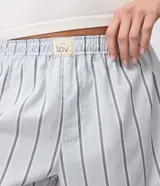 Short de pijama Lov confeccionado en tricolina de algodón, con diseño holgado, estampado a rayas celestes y grises, y cintura elástica con etiqueta frontal de la marca.