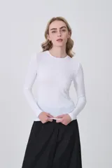 Remera de manga larga ajustada al cuerpo, color blanco, con cuello redondo bajo y tejido acanalado.