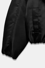 Chaqueta bomber negra ZW Collection con acolchado interior, cuello envolvente de solapa cruzada, mangas largas con puños elásticos y bajo con elástico.