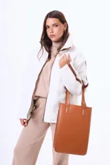 Bolso tipo tote de diseño estructurado y formato vertical, confeccionado en cuero sintético con textura grabada tipo cocodrilo. Cuenta con doble asa de hombro y cierre lateral.