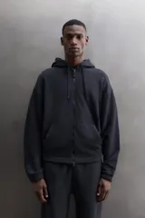 Sudadera con capucha y cierre de cremallera de doble dirección, color negro, de corte relaxed fit, con bolsillos frontales tipo canguro y puños y bajo elásticos.