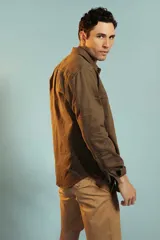 Bermuda de gabardina color tostado, de corte recto y largo por encima de la rodilla, con cierre y botón frontal.
