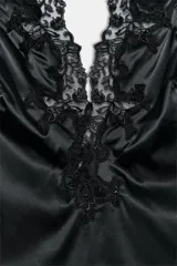 Body de tejido satinado con cuello halter y escote en pico. Presenta hombros descubiertos y aplicaciones de encaje a tono en el escote. Cierre inferior con botones a presión.