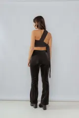 Top negro de un solo hombro con frunces y lazo lateral.