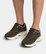 Championes deportivos para hombre en color verde militar, con diseño chunky, capellada de malla y detalles de material sintético. Cuentan con cordones y suela de goma blanca con volumen.
