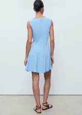 Vestido corto sin mangas color celeste, con cuello barco, diseño de tablas y cierre de cremallera en la espalda.