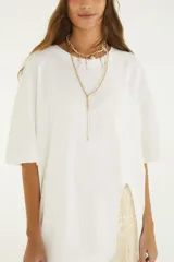 Remerón oversize de cuello redondo, color blanco, de manga corta y corte amplio con abertura lateral.