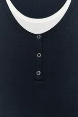 Camiseta efecto doble en color crudo y blanco, de manga corta y corte slim fit. Cuenta con escote redondo, cierre frontal parcial con botones a presión y diseño de capas superpuestas.