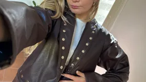 Campera corta de ecocuero color marrón chocolate, con diseño de solapas decoradas con tachas metálicas plateadas y cierre frontal.