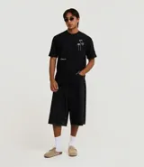 Remera relaxed de algodón y poliéster color negro, con cuello redondo, manga corta y estampa bordada de cocoteros y sol.