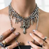 Collar plateado de acero quirúrgico con dijes colgantes de cruces, puntas y esferas.