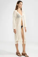 Cárdigan largo color crema de punto abierto con flecos en el ruedo y lazo de ajuste en el escote.