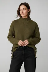 Sweater de punto de cuello alto, manga larga y diseño holgado, con detalle de flecos en los laterales.