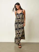 Vestido largo con estampado tipo ikat en tonos oscuros y dorados, de corte recto y tirantes anchos.