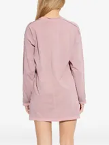 Vestido corto de algodón color rosa, de corte relajado, manga larga y cuello redondo. Presenta costuras externas visibles y el logo de la marca bordado en el pecho.