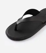 Sandalias de dedo para hombre, confeccionadas en material sintético con tiras anchas, diseño limpio, suela plana y acabado uniforme.