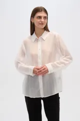 Camisa celeste de lyocell con textura arrugada, corte holgado, cuello clásico y cierre frontal con botones.
