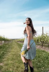 Vestido corto celeste con breteles finos, corte a la cintura, falda con volados y detalle de encaje en ruedo y cintura.