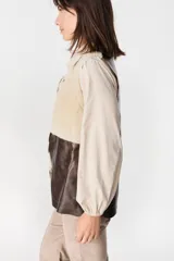 Chaleco de cuero marrón con interior y solapas de piel sintética color crudo. Diseño sin cierre, con corte recto y acabado texturizado.