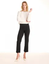 Pantalón cigarette negro de tiro alto, confeccionado en tejido elastizado. Presenta un corte ajustado que se mantiene recto hacia el ruedo, terminando por encima del tobillo. Diseñado con pretina ancha y plana sin cierres ni botones, y una costura vertical pronunciada a lo largo de cada pierna.