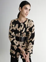 Saco acolchado con estampado abstracto en negro y beige, cuello redondo, cierre con botones a presión y bolsillos laterales. Incluye cinturón ancho de cuero negro con hebilla rectangular.