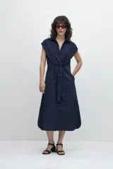 Vestido camisero midi azul marino con cuello, mangas cortas, cierre frontal con botones y cinto del mismo material.