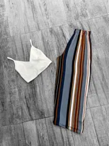 Pantalón palazzo con cintura elastizada y estampado a rayas verticales en tonos azul, marrón, blanco y negro.