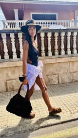 Traje de baño entero color negro, con escote en V y tirantes finos que se cruzan en la espalda. Presenta cortes laterales con tiras ajustables que se anudan a los costados.