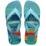 Sandalias tipo ojota Havaianas, color azul con estampa vibrante de atardecer tropical con olas y vegetación en tonos azules, verdes, naranjas y amarillos. Tiras celestes con logo en relieve.