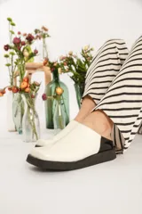 Zuecos color blanco con punta cuadrada y suela negra.