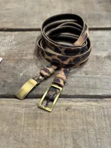 Cinto de cuero sintético con estampado animal print de leopardo y hebilla metálica dorada.