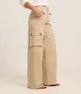 Pantalón de sarga color beige, de corte wide leg, con bolsillos cargo laterales y cintura alta.