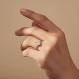 Anillo de plata 925 con diseño de árbol en la parte superior, adornado con pequeñas piedras brillantes.